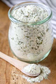 a jar filled with white stuff next to a wooden spoon