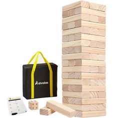 a wooden block tower next to a bag and two pieces of wood on the ground