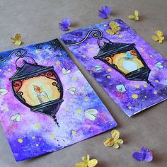 two paintings are shown on the ground with butterflies around them and one is holding a candle