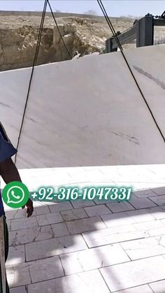 a man standing on top of a cement slab next to a green and white sign