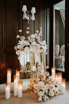 a table topped with lots of white flowers and candles