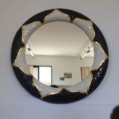 a round mirror hanging on the wall