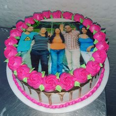 a cake decorated with pink roses and photos