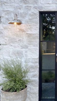 a woman standing in front of a white brick building