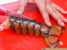 a person is cutting up some food on a red board with a large pair of scissors