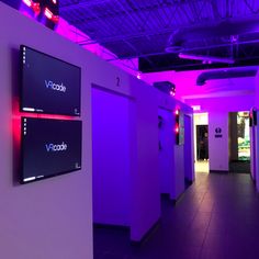 a hallway with purple lighting and neon signs on the walls that read vascode