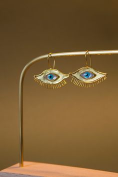 ✨Discover the artisan blue evil eye earrings, a unique and handmade piece of jewelry that will add a touch of style and elegance to any outfit. These earrings are crafted from brass and feature a stunning gold finish that will catch the eye and make a statement. The intricate design of the evil eye adds an element of mystique and symbolism to the piece, making it a conversation starter and a piece that is sure to be noticed. ✨ The evil eye dangle earrings are designed with a comfortable ear wire Wire Jewelry Eye, Handmade Evil Eye, Evil Eye Design, Evil Eye Earrings, Jewelry Care Instructions, Green Jewelry, Blue Evil Eye, Eye Earrings, Conversation Starters