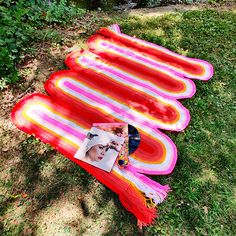 an image of a blanket laying on the ground next to a photo and some other items