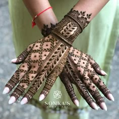 a woman's hands are decorated with henna