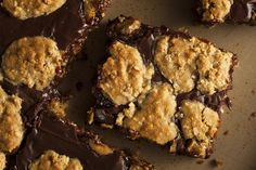 chocolate chip cookie bars are arranged on a sheet of parchment paper, ready to be eaten