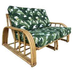 a green and white chair with palm print upholstered on the armrests