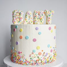 a birthday cake decorated with sprinkles and letters