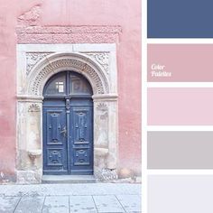 a blue door is in front of a pink building