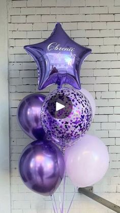 purple and white balloons in front of a brick wall