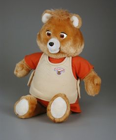 a brown teddy bear wearing an orange shirt