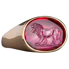 This exquisite intaglio is masterfully engraved onto man made corundum and features a lion. The intaglio is set in an 18K gold signet ring. Production time for this piece is 12-14 weeks. Can be made in any size ranging from 8-12. Chavdar Chushev is an artist, restorer, jeweler, and master of the ancient art of gem carving. His extensive knowledge of gemstones and precious metals is complimented by a familiarity with more unusual materials, such as exotic woods, organic gems, and fossils. This un Luxury Formal Signet Ring With Intaglio, Luxury Carved Yellow Gold Signet Ring, Elegant Red Intaglio Signet Ring, Luxury Round Signet Ring With Intaglio, Luxury 14k Gold Signet Ring With Intaglio, Luxury Engraved Ruby Ring, Luxury Oval Signet Ring With Intaglio, Luxury Carved Oval Signet Ring, Elegant Oval Ruby Ring With Intaglio