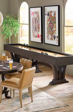 a dining room with a pool table, chairs and pictures on the wall above it