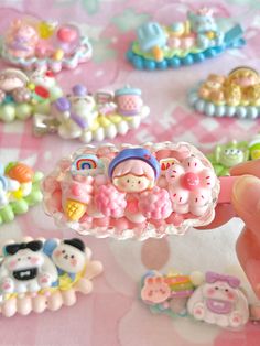 a person is holding a small plastic brooch in front of many other toy items