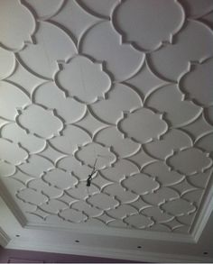 the ceiling is decorated with white paint and decorative designs on it's surface,