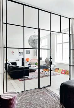 a living room filled with furniture and lots of mirrors on the wall next to a window