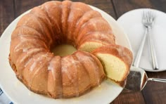 a bundt cake sitting on top of a white plate next to a knife and fork