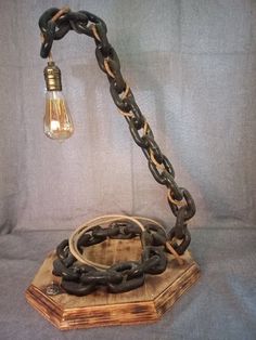 a lamp that is on top of a wooden block with chains hanging from it's sides