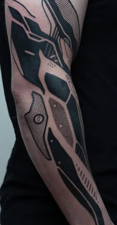 a man with a black and grey tattoo on his arm