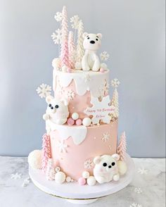 a pink and white cake with teddy bears on top