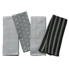 three black and white towels are next to each other on a white background, one is folded