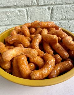 a yellow bowl filled with pretzels sitting on top of a table