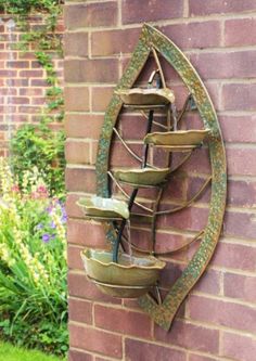 a water fountain mounted to the side of a brick wall