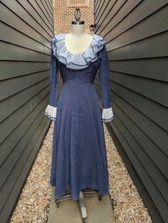 "A beautiful 1960s-70s blue polka dot dress with ruffle collar and sleeve cuffs!! Fully Lined. Has a very fitted bodice and dramatic skirt. In Good condition.The lining has discoloration. No label, see measurements below for sizing. Most Likely polyester Garment Measured Flat (In inches) Bust: 33\" Waist: 37\" Hip: 40\" Length: 45 1/2\" Sleeve Length: 23\" Armhole opening: 19\" Sleeve opening: 9\"" Dramatic Skirt, Overalls Vintage, Vintage Overalls, Blue Polka Dot Dress, Vintage Ysl, 80s Dress, Vintage Maxi Dress, 70s Dress, Ruffle Collar