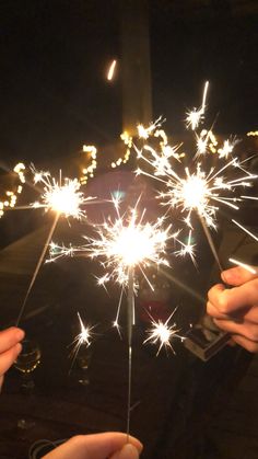 two people are holding sparklers in their hands