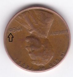 a close up of a penny with an arrow pointing to the right and left side