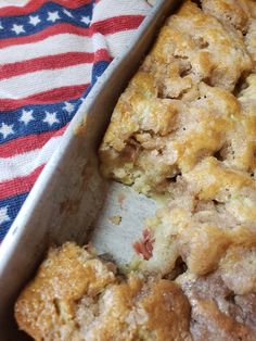 a casserole dish filled with bread and toppings on top of an american flag cloth