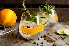 two glasses filled with lemonade and garnished with herbs