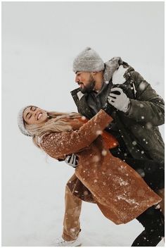 a man carrying a woman in the snow