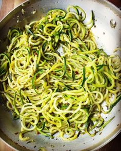 zucchini noodles are being cooked in a pan