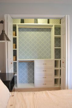 a bed sitting under a window next to a closet