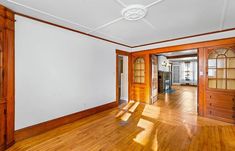 an empty room with wood floors and white walls