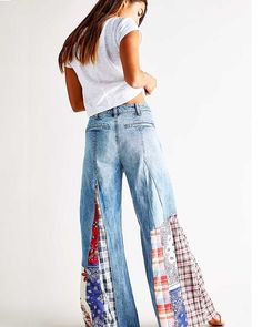 a woman standing with her back to the camera wearing high waist jeans and white t - shirt