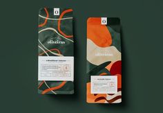 two bags of coffee sitting next to each other on a green surface with an orange and white design