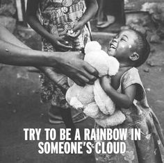 a black and white photo of a child being held by someone's hand with the caption try to be a rainbow in someone's cloud