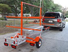 an orange and silver trailer attached to a car