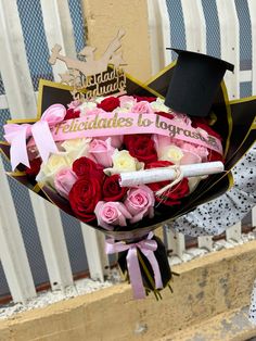 a bouquet of roses with a graduation cap on top