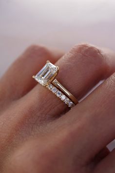 a woman's hand with a diamond and gold ring on top of her finger