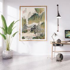 a painting hanging on the wall next to a desk with a computer and camera in front of it