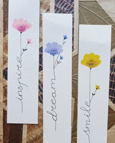 three bookmarks with flowers painted on them