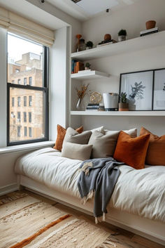 a white couch sitting in front of a window filled with lots of pillows and blankets