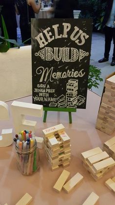 there is a sign that says help us build memories on the table with markers and pencils